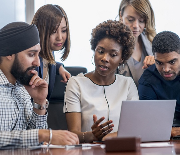 Group of students looking at something on a computer.